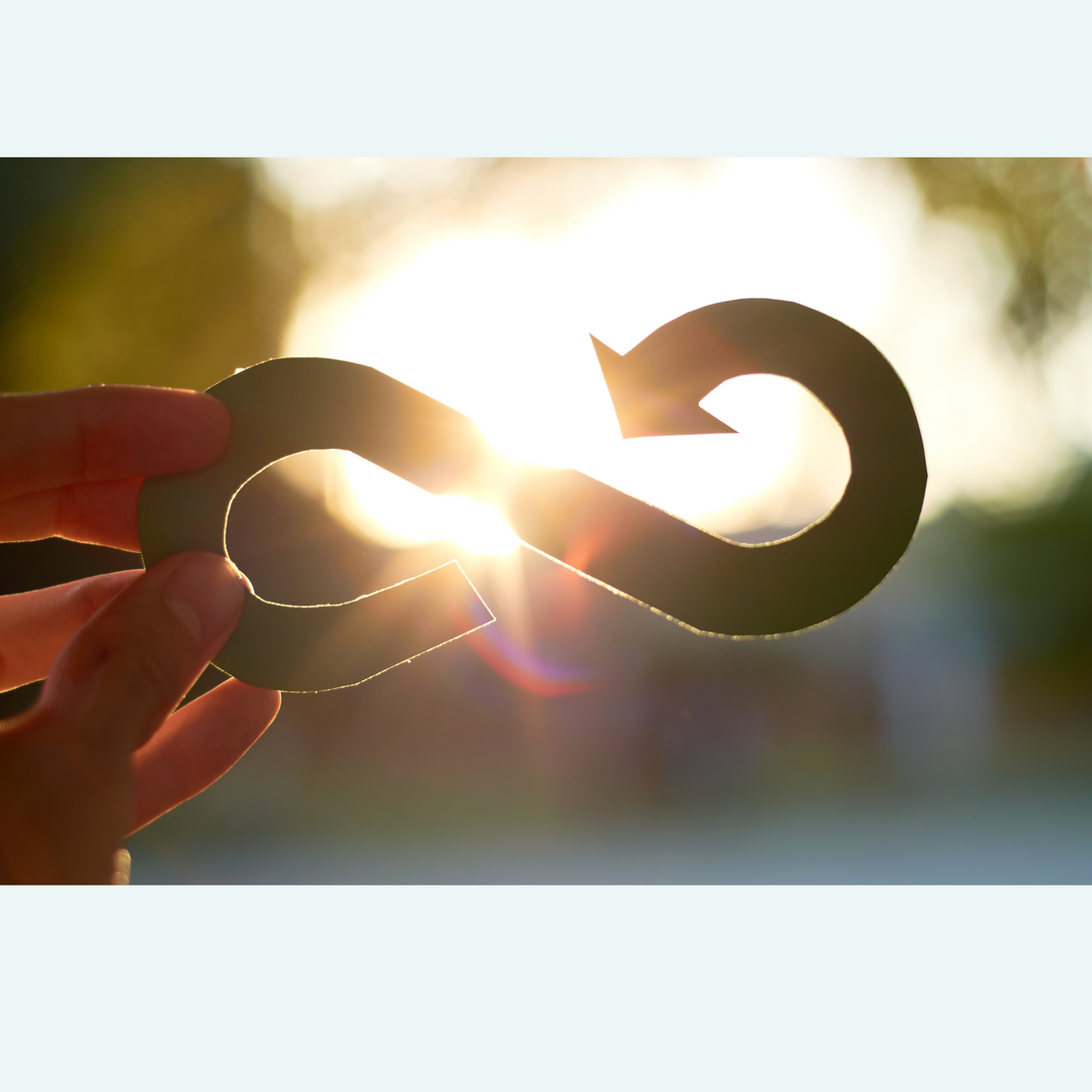 Circular recycling symbol with sunlight coming through