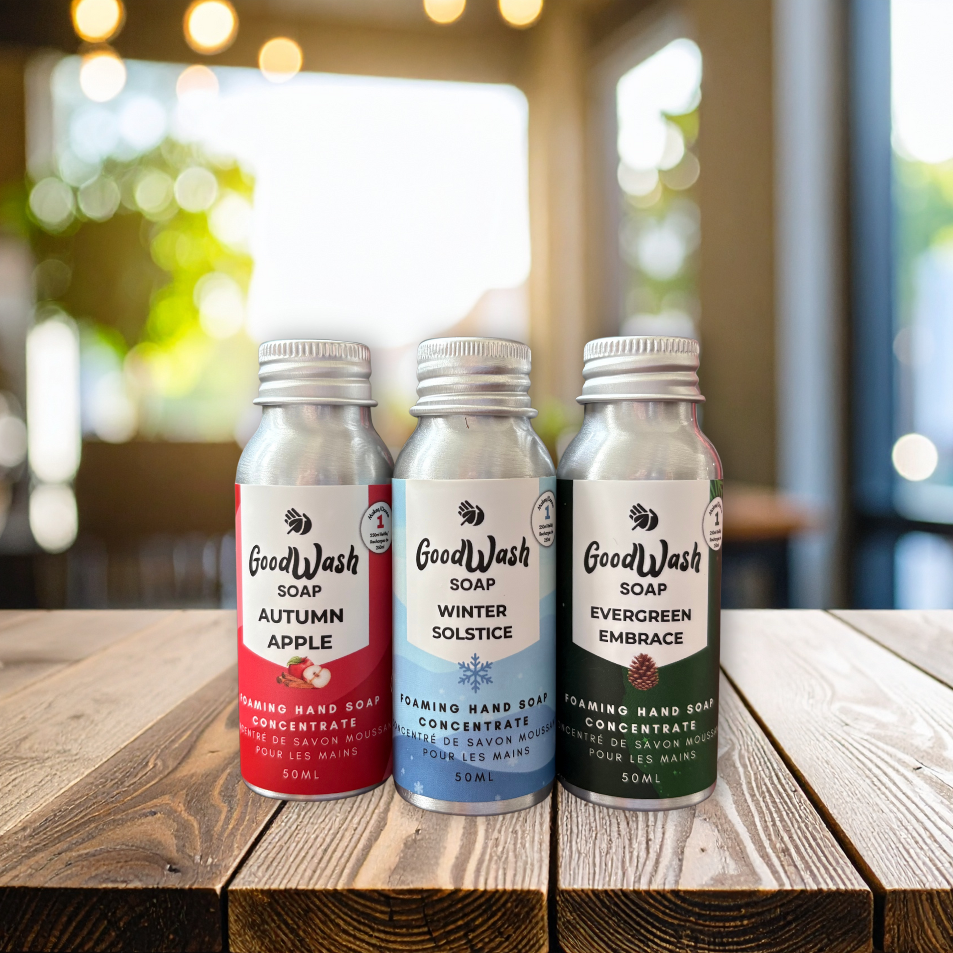 Three bottles of Good Wash soap on a wooden surface with a blurred background